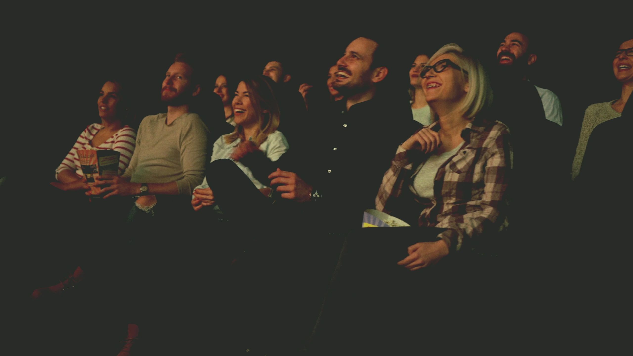 Group of friends laughing while watching a show